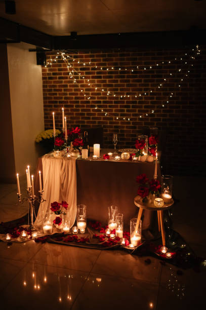 istock Romantic dinner setup at night. Champagne glasses, flowers. Table setting for a couple, Valentine's Day evening, burning candles for a surprise marriage proposal. Candle light date in a restaurant. 1924344784