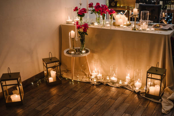 istock Candlelight date in restaurant. Glasses with wine, bouquet flowers. Romantic dinner setup at night. Table setting for couple, Valentine's Day evening, burning candles for surprise marriage proposal. 1924345149