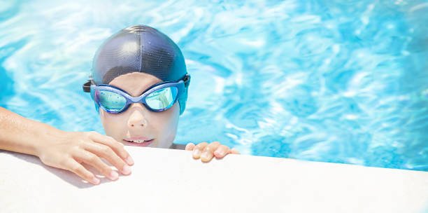 istock Happy child (boy) ready to learns swimming in swimming pool. 1924347064