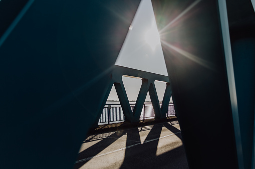 The sun shines on the bridge or through the bridge. Backlit shot. Architectural photography