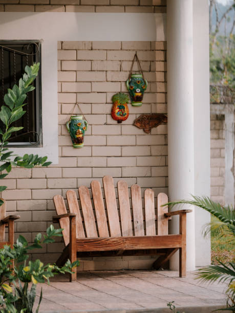 istock Rustic wooden bench positioned on a stylish patio, with hanging vase designs 1924359609