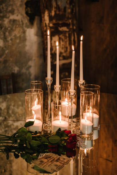 istock Luxurious rustic style table on background of evening lighting in restaurant for gala dinner. Mirror table for a party. Chic table is decorated with candles, flowers and money for wedding invitations. 1924370529
