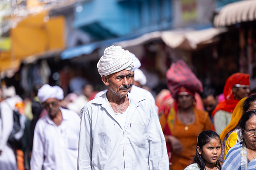 Pushkar, Rajasthan, India - November 2022: Pushkar fair, Portrait of an rajasthani old male with in white traditional dress and white turban at pushkar fair ground.