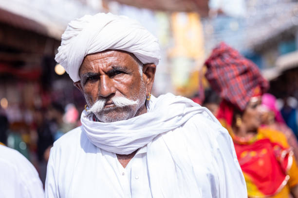 Pushkar, Rajasthan, India - November 2022: Pushkar fair, Portrait of an rajasthani old male with in white traditional dress and white turban at pushkar fair ground.