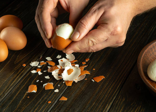 istock Cooking a delicious lunch with boiled eggs on the kitchen table. Shelling an egg with the hands of a chef 1924381452