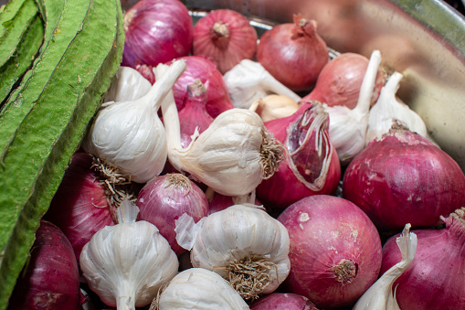 Ridge gourd, onion and garlic closeup on vintage wooden background, harvesting. Healthy food, vitamins