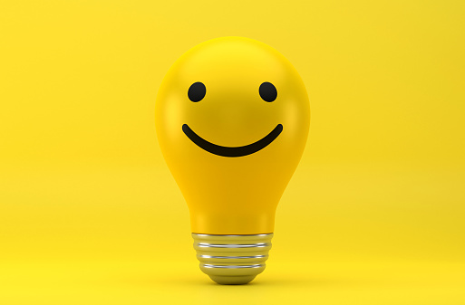 Light Bulb And Happy Emoji On Yellow Background.