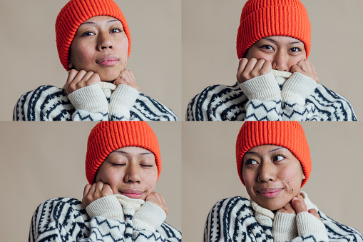 An image montage of portraits of a young woman wearing a knit jumper and hat, standing in front of a brown background in a studio in Newcastle upon Tyne. She is doing different poses with her arms next to her face while keeping warm and cosy.