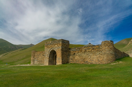 The Tash Rabat fortress, historic caravanserai, stout stone masonry and defensive arches in Kyrgyzstan's pastoral hills, its preserved edifice, the caravan culture of the Silk Road, Central Asian