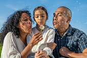 Family blowing dandelion seeds