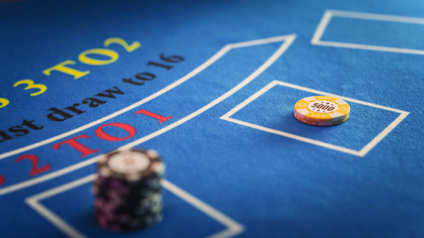 istock Close Up on Casino Baccarat Gambling Table: Anonymous Croupier Dealing Playing Cards on a Blackjack Table with Bet Chips in Place. Poker Chips are Being Exchanged as the Lucky Guest Wins the Jackpot 1924449037