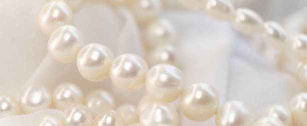 istock A cascade of pearls rests on a soft, white cloth, their natural luster dimly reflecting light. The delicate arrangement echoes the timeless appeal of authenticity in a world chasing after the artificial. 1924454450
