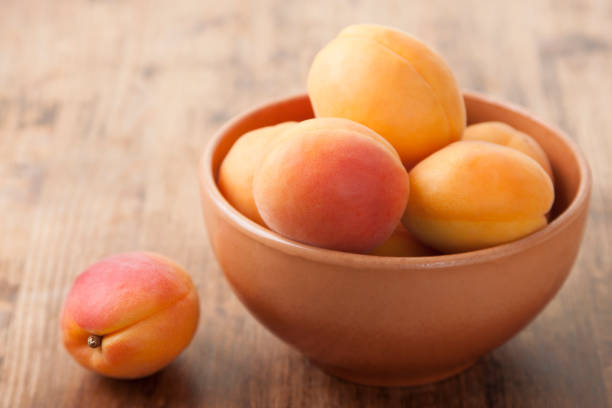 istock Apricots in a clay bowl on a wooden table 1924524505