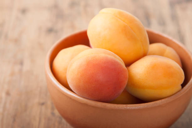 istock Apricots in a clay bowl on a wooden table 1924524506