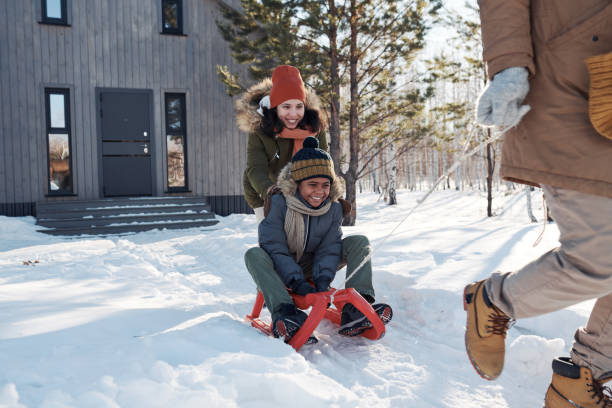 istock Happy young woman pushing son on sledge 1924555981