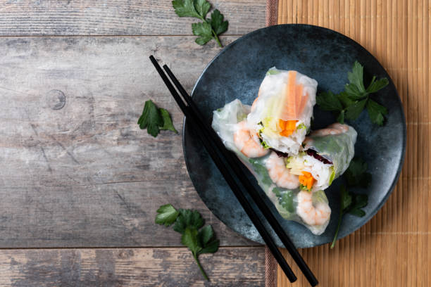 istock Vietnamese spring rolls with vegetables, rice noodles and prawns on wooden table 1924565210