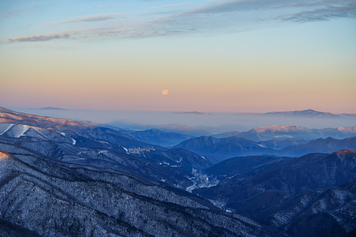 Moon with snowing mountain range