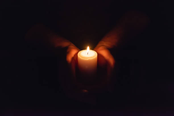 istock Hands holding burning candle in dark like a heart.Selective focus,black background.Copy space. 1924577626