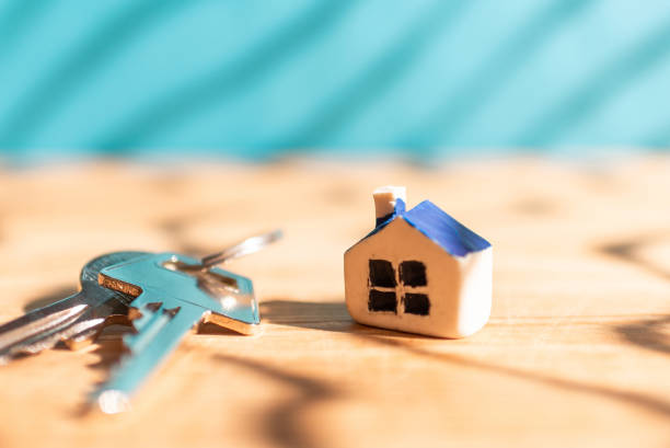 casa nueva en miniatura con llaves de la casa sobre fondo borroso azul de madera, concepto de negocio inmobiliario y de propiedad. primer plano, enfoque selectivo. - 6721 fotografías e imágenes de stock