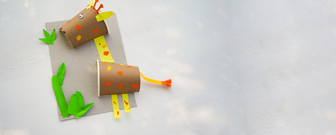 Craft Paper Cup animal cartoon character. DIY Homemade giraffe applique from a paper cup. Kids craft giraffe from a paper coffee cup, zero waste concept.