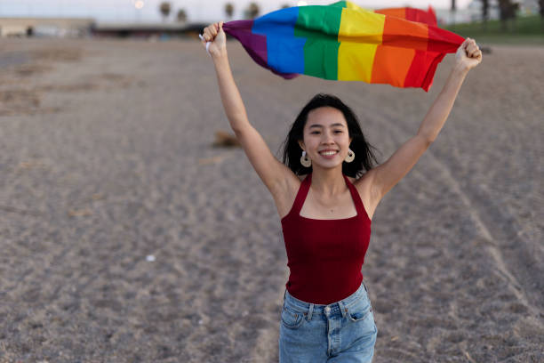 istock Happy girl with a pride flag at the beach. 1924603049
