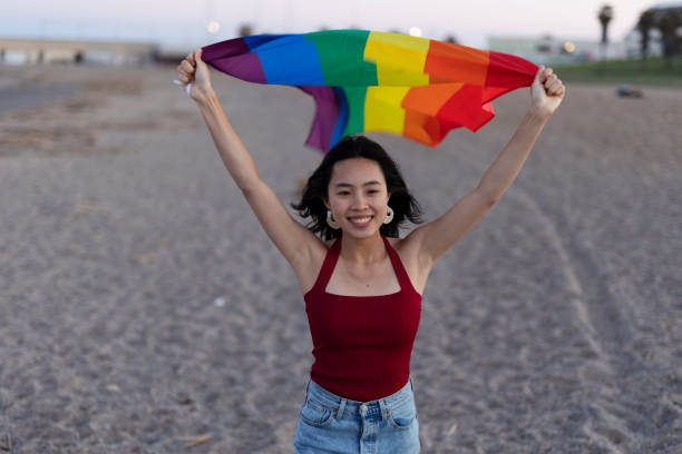 istock Happy girl with a pride flag at the beach. 1924603578