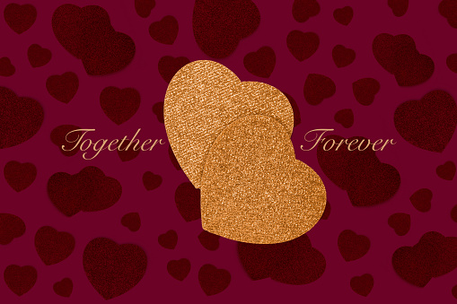 Together Forever. Love concept with overlapping textured gold hearts on a romantic purple patterned heart background with copyspace. Commitment of love for your loved one
