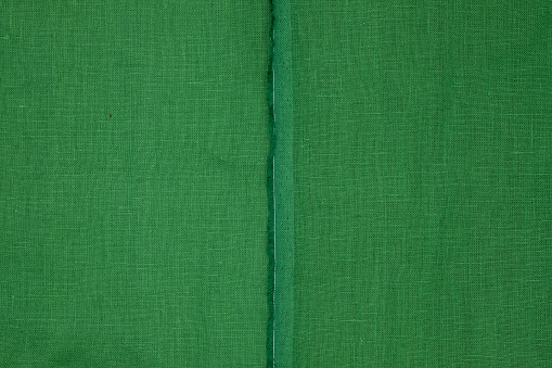 Green linen fabric texture. Edge of the cloth. Copy space.