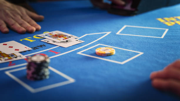 istock Close Up on Casino Baccarat Gambling Table: Anonymous Croupier Dealing Playing Cards on a Blackjack Table with Bet Chips in Place. Poker Chips are Being Exchanged as the Lucky Guest Wins the Jackpot 1924652352