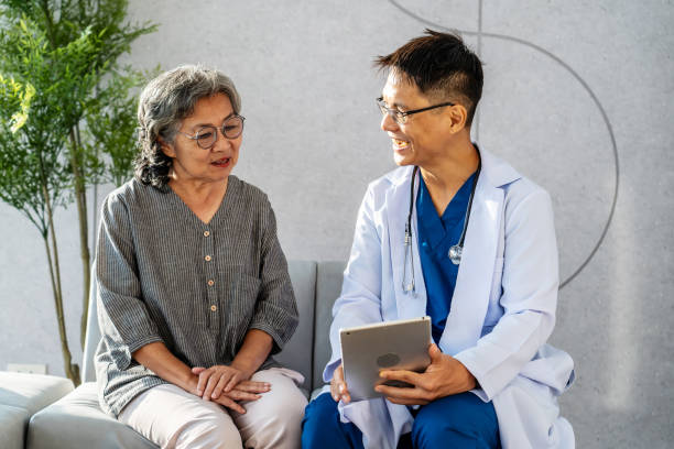 istock Cheerful doctor holding a tablet consulting the patient 1924653458