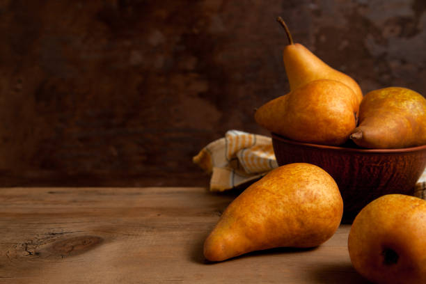 Fruit background image. Ripe juicy pear fruits on vintage wooden background.