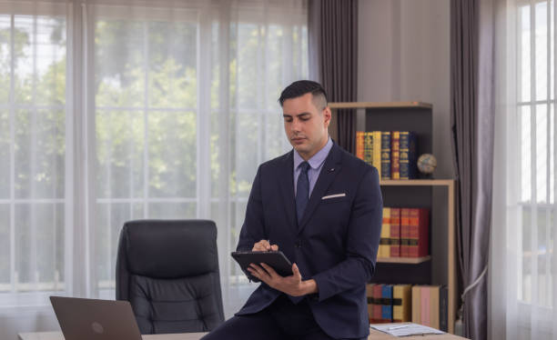 istock Male manager in suit multitask on laptop, tablet in modern office, talk to clients, analyze project 1924682691