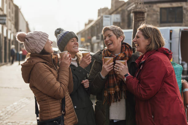 laughing over coffee - disposable cup coffee shopping friendship стоковые фото и изображения