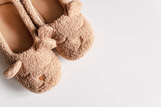istock Beige warm teddy bear slippers. Top view. Copy space 1924706388