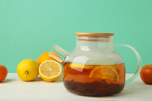 Black tea with lemon on mint background. Top view