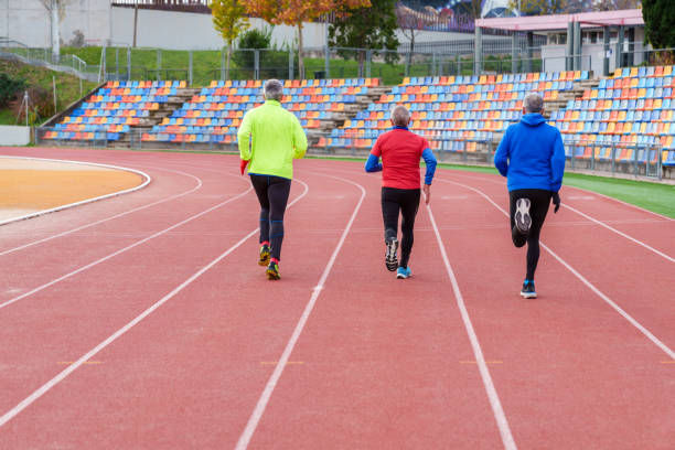 istock Senior Runners Jogging Together on a Red Track 1924755554