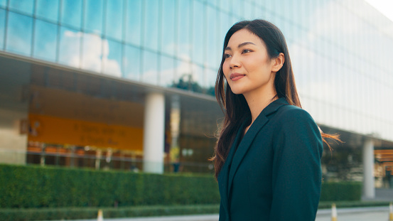 Beautiful young Asian businesswoman in business attire walking to office with high skyscraper view outdoor, Confident executive director with smart business outfit, Professional female manager working at modern office building, Business people at work