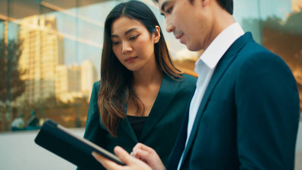 istock Professional young Asian business people team using digital tablet, consulting, discussing financial market plan and working in modern office building 1924761002