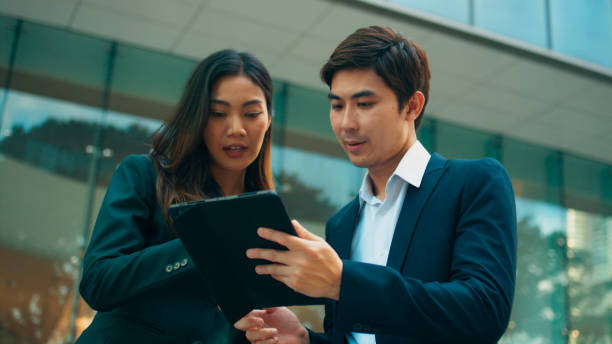 istock Professional young Asian business people team using digital tablet, consulting, discussing financial market plan and working in modern office building 1924761019