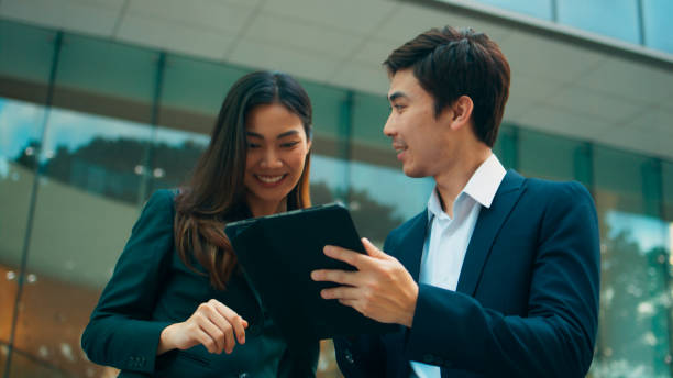 istock Professional young Asian business people team using digital tablet, consulting, discussing financial market plan and working in modern office building 1924761031