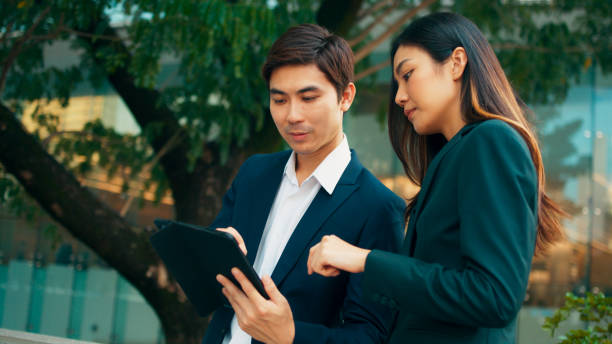 istock Professional young Asian business people team using digital tablet, consulting, discussing financial market plan and working in modern office building 1924761058