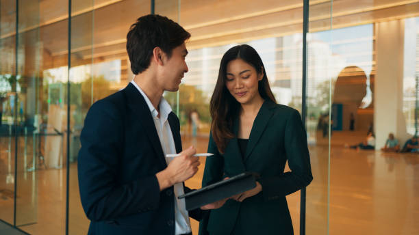 istock Two happy professional young Asian business people team using digital tablet, working together, meeting and discussing financial market plan in modern office building 1924763751