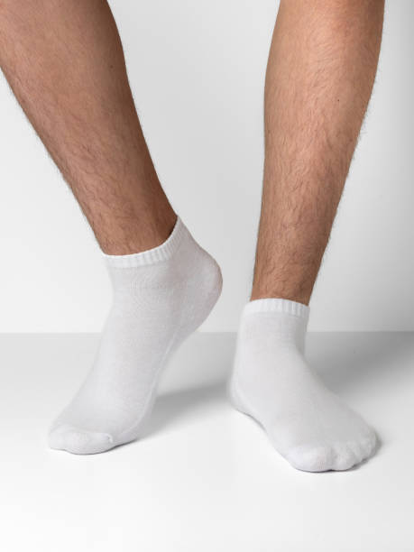 istock Male feet wearing white cotton socks on white background 1924792377