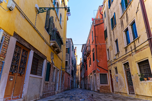 Alley with weathered facades at the old town of Italian City of Venice on a sunny summer day. Photo taken August 6th, 2023, Venice, Italy.