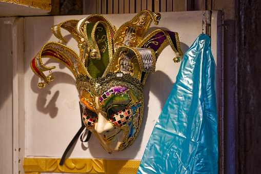 Old town of Venice with close-up of carnival mask at shop window on a blue cloudy summer day. Photo taken August 6th, 2023, Venice, Italy.