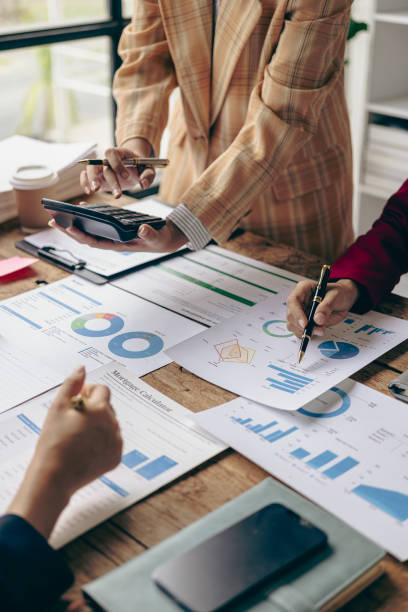 istock Business team Two managers work on accounting documents and the team works together to give presentations and help solve problems with accounting documents. Close-up vertical image 1924807507