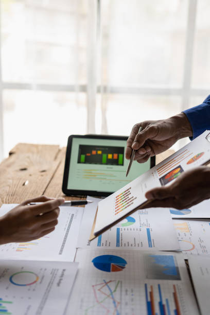 istock Business team Two managers work on accounting documents and the team works together to give presentations and help solve problems with accounting documents. Close-up vertical image 1924808037