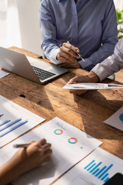 istock Business team Two managers work on accounting documents and the team works together to give presentations and help solve problems with accounting documents. Close-up vertical image 1924808040