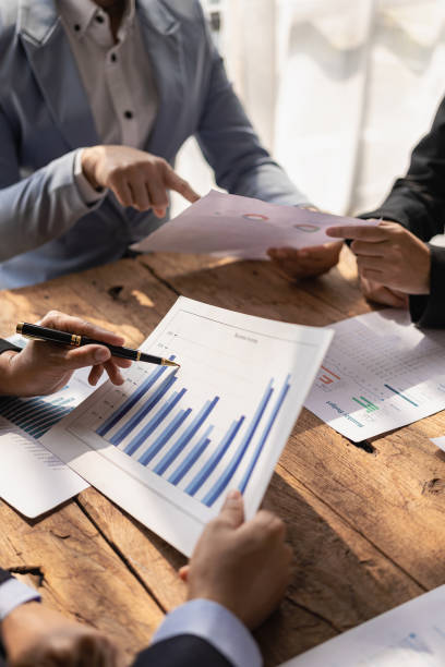 istock Business team Two managers work on accounting documents and the team works together to give presentations and help solve problems with accounting documents. Close-up vertical image 1924808048