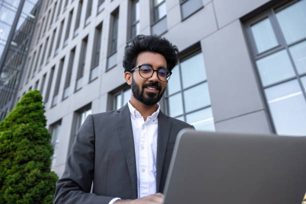 istock Brunette young businessman working on laptop and feeling contented 1924835531
